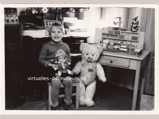 Kindheit in der DDR, Kind mit großem Teddy, Puppe und Kaufladen