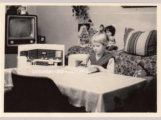 Kind mit Nähmaschine von Piko, Puppen und Puppenbad von Linus Dähnert